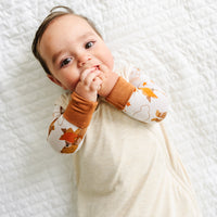 Close up image of a child wearing a Heather Oatmeal sleepy bag and coordinating zippy