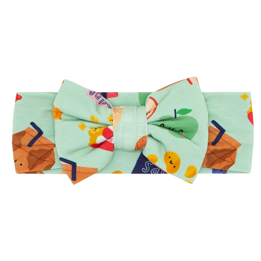 Flat lay image of a Snack Attack luxe bow headband