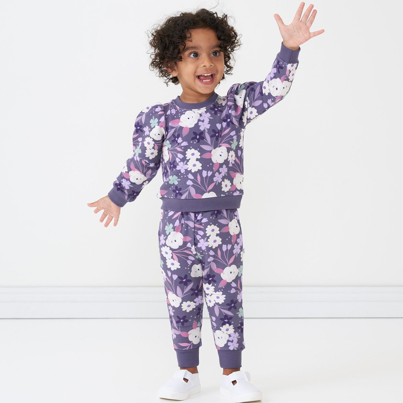 Child wearing Sugar Plum Floral joggers paired with a matching crewneck sweatshirt