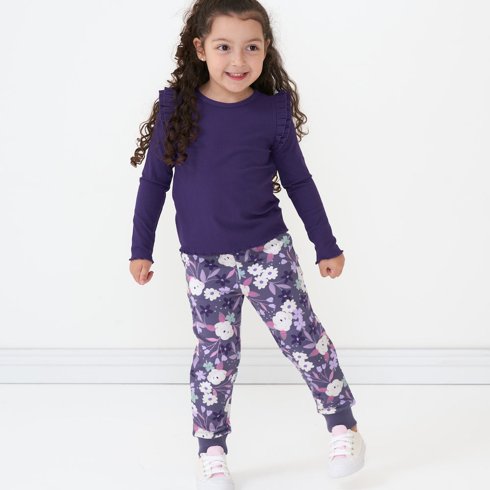 Child wearing Sugar Plum Floral joggers paired with a Deep Amethyst flutter lettuce tee