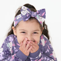 Close up image of a child wearing a Sugar Plum Floral luxe bow headband