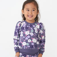 Close up image of a child wearing a Sugar Plum Floral puff sleeve crewneck