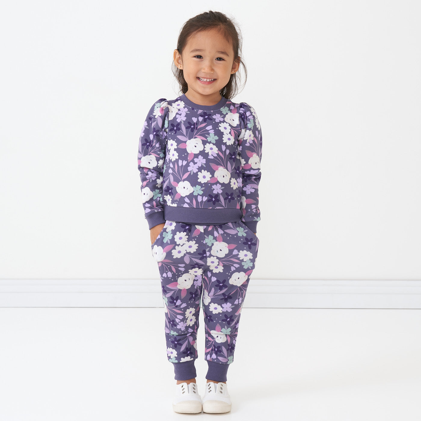 Child wearing a Sugar Plum Floral puff sleeve crewneck paired with matching joggers