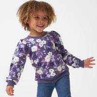 Child posing wearing a Sugar Plum Floral puff sleeve crewneck