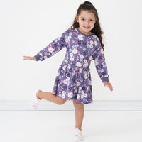 Child posing wearing a Sugar Plum floral drop waist dress