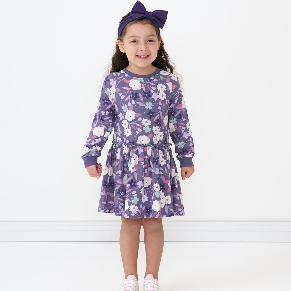Child wearing a Sugar Plum floral drop waist dress paired with an Amethyst luxe bow headband  