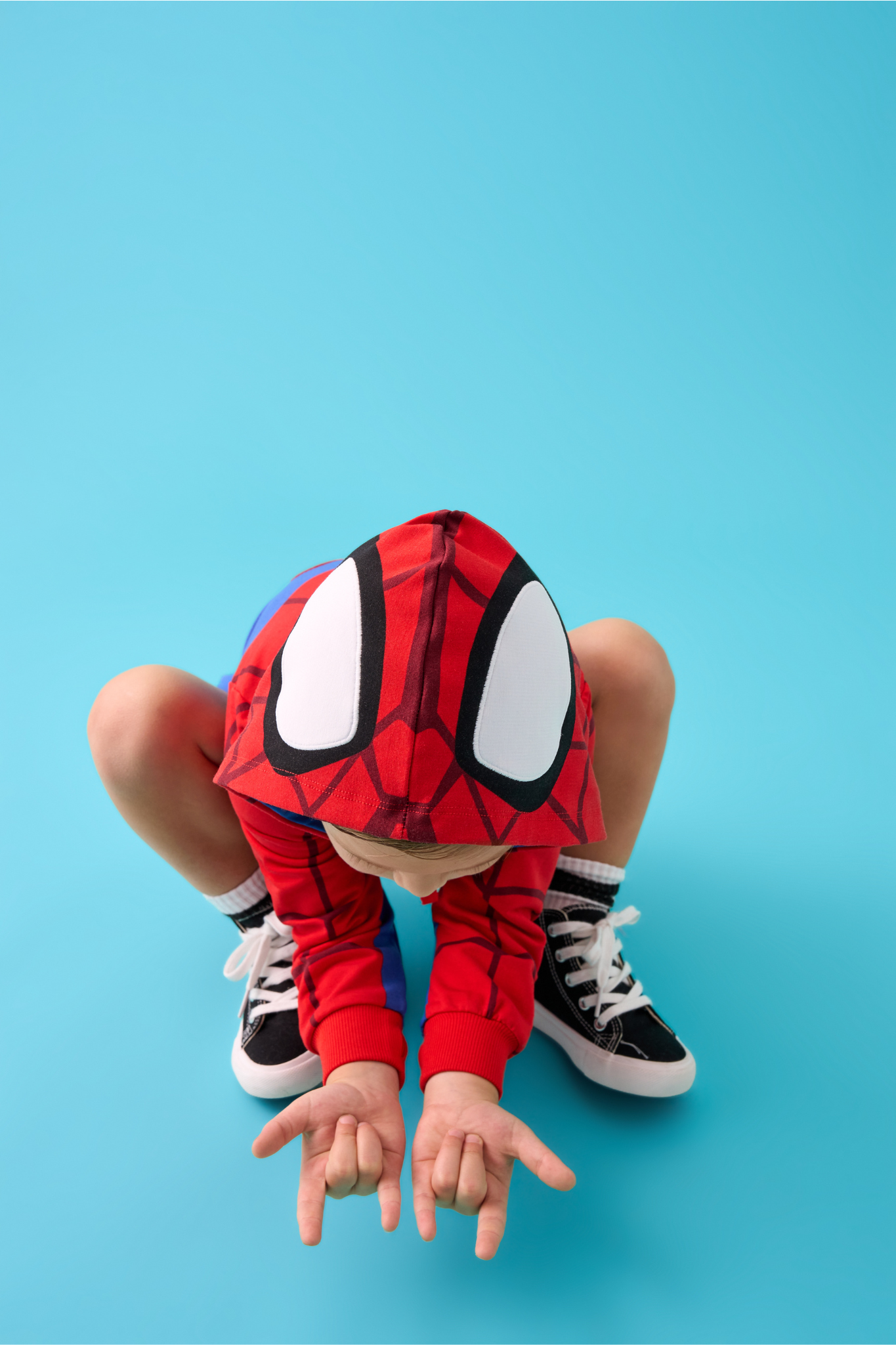 Child crouching down wearing a Spidey Zip Hoodie