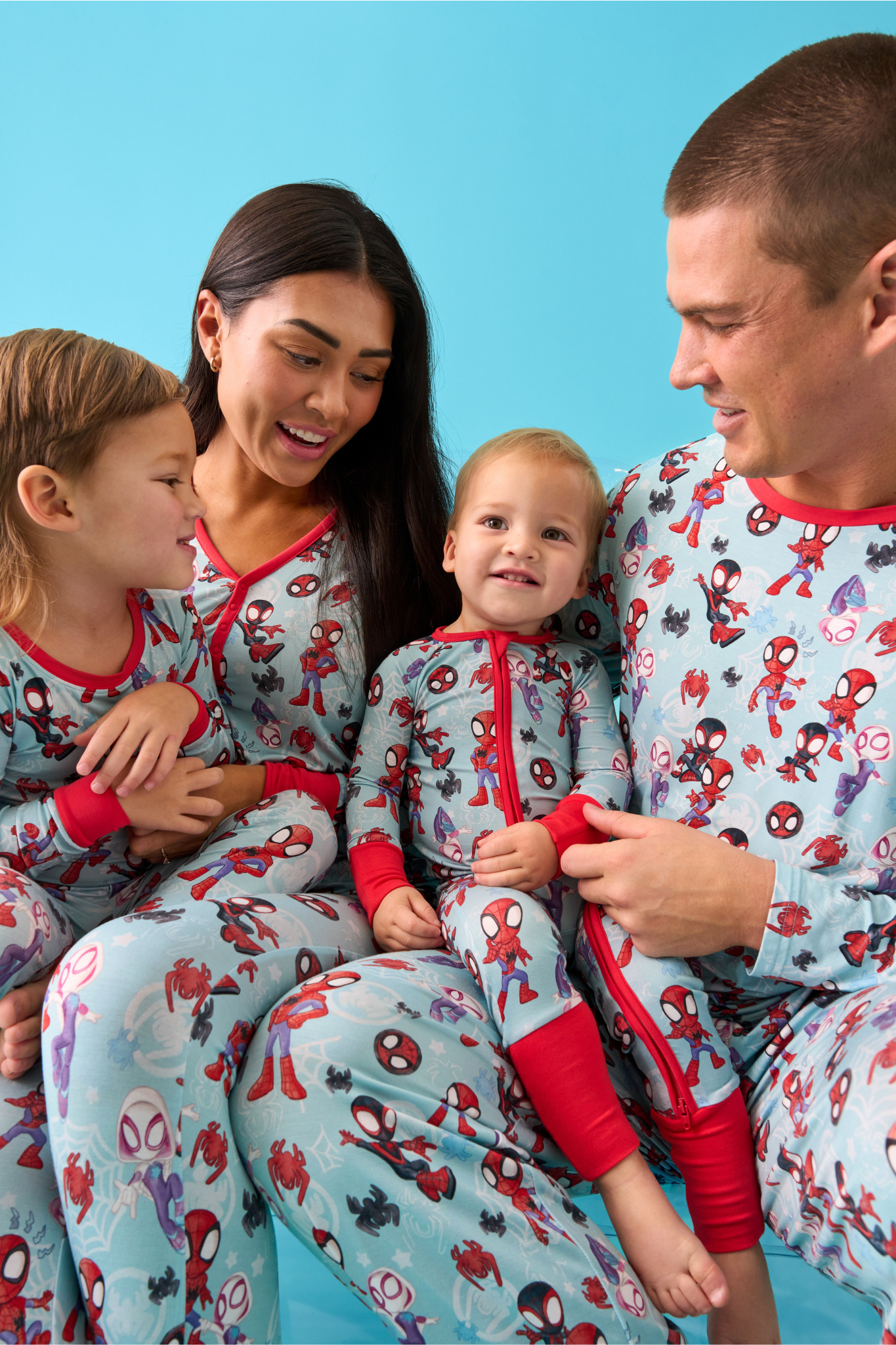 Family of four wearing matching Tiny Webs pajamas