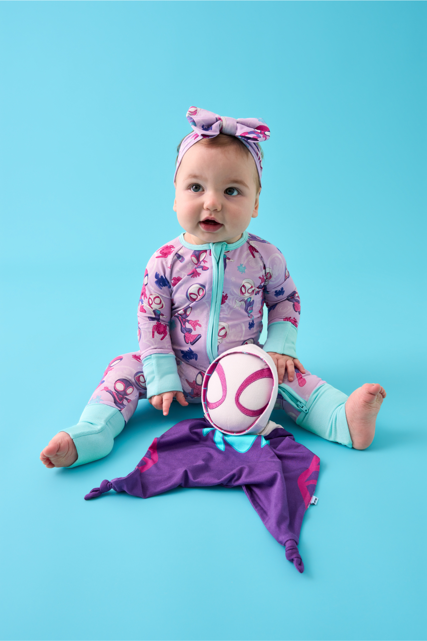 Child wearing a Purple Tiny Webs Zippy and Luxe Bow Headband with a Ghost-Spider Lovey