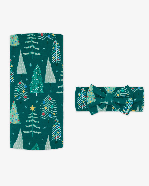Flat lay of the Twinkling Trees Swaddle & Luxe Bow Headband Set