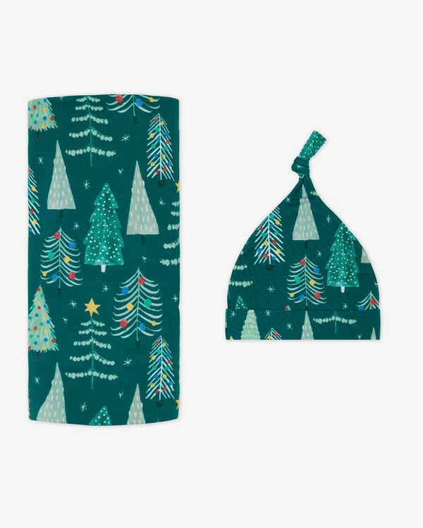 Flat lay of the Twinkling Trees Swaddle & Hat Set