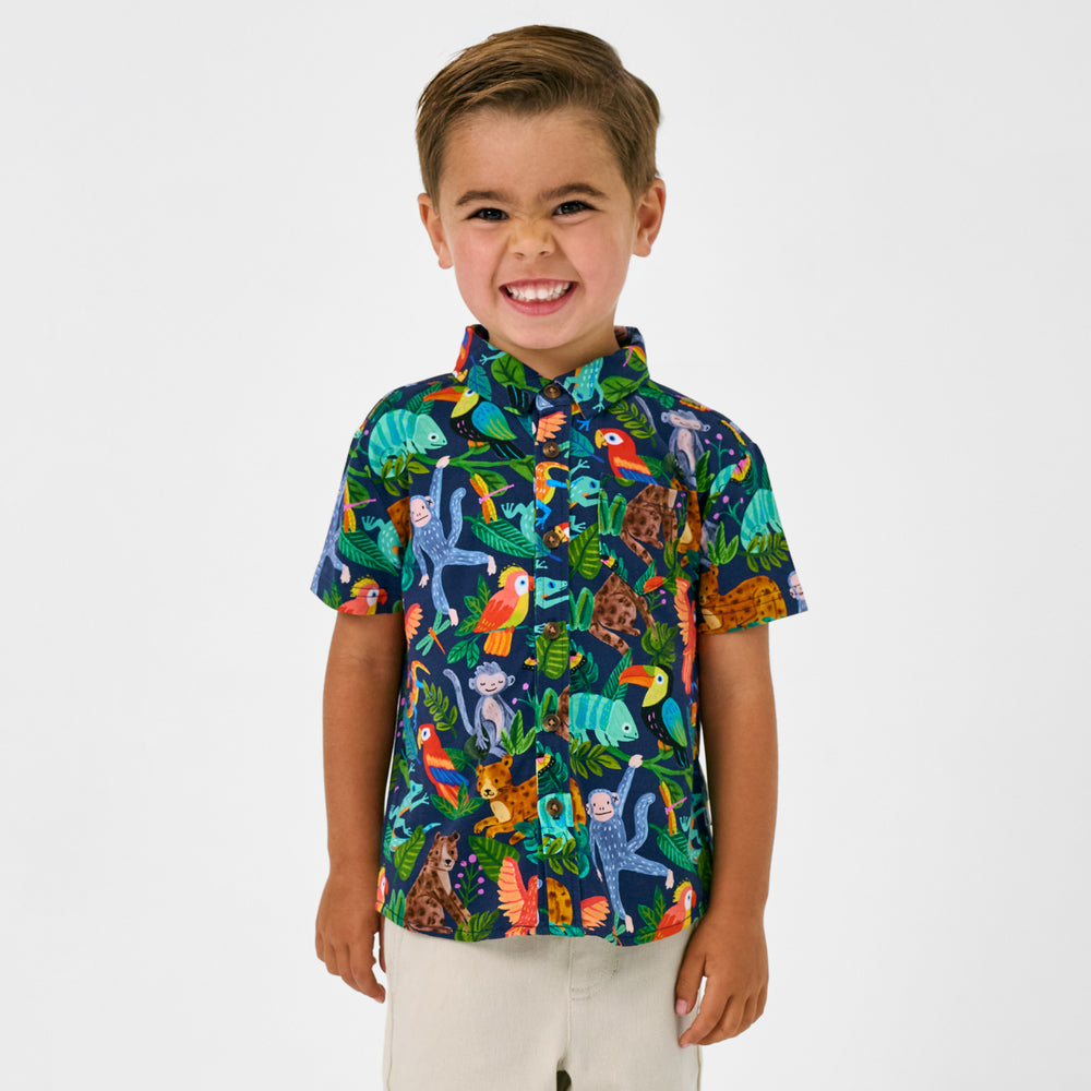 Smiling child wearing the Treetop Tails Button Down Polo
