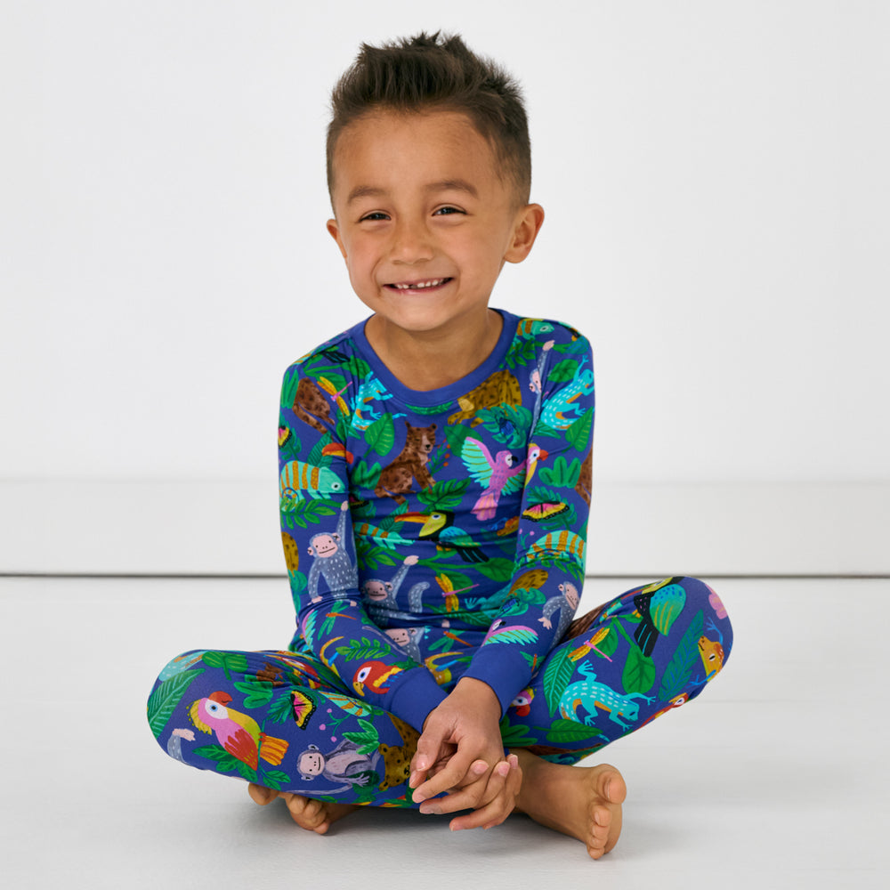 Sitting child wearing the Treetop Tails Two-Piece Pajama Set