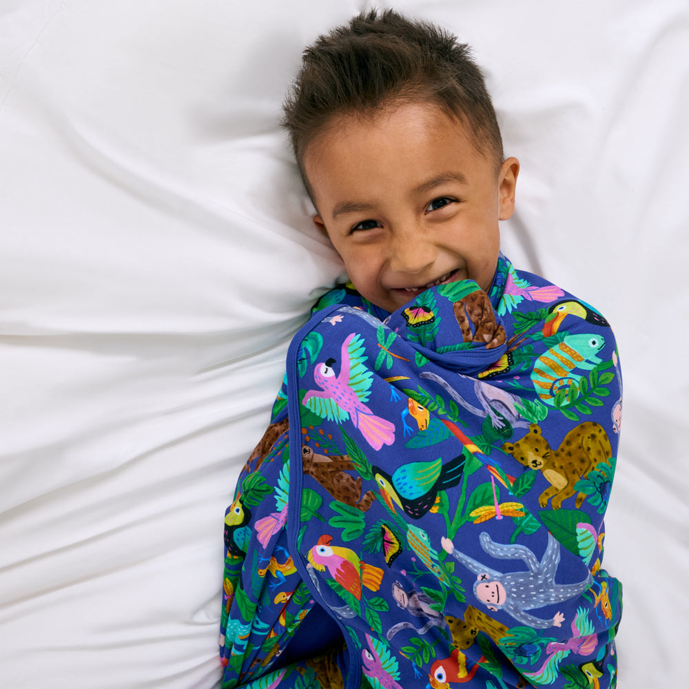 Aerial view of child wrapped in the Treetop Tails Large Cloud Blanket®