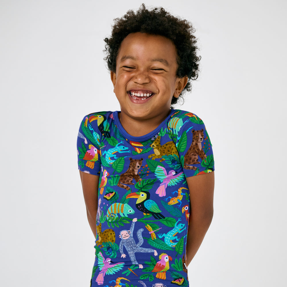 Close up of laughing child wearing the Treetop Tails Two-Piece Short Sleeve & Shorts Pajama Set
