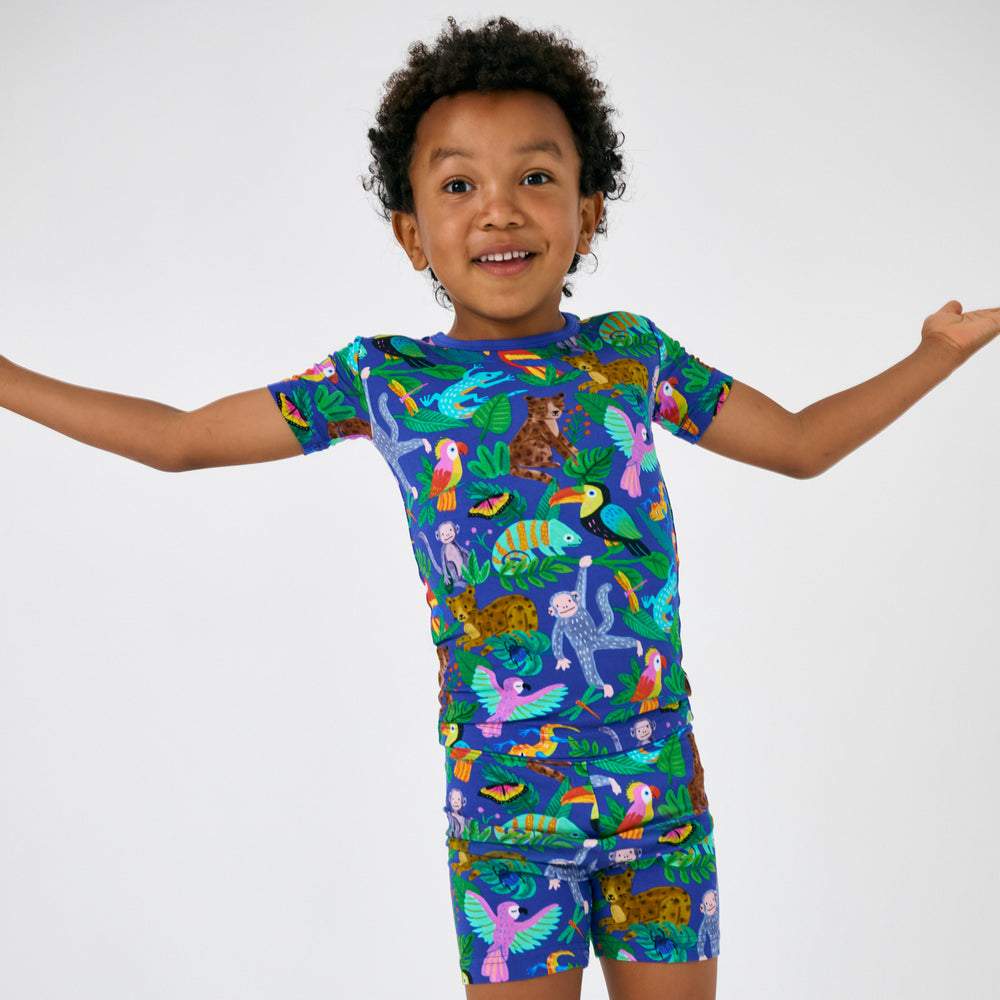 Posing child wearing the Treetop Tails Two-Piece Short Sleeve & Shorts Pajama Set