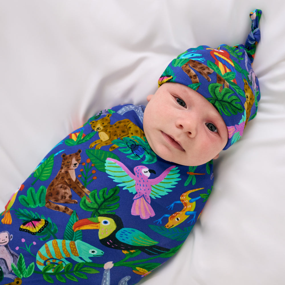 Close up aerial view of child wearing the Treetop Tails Swaddle & Hat Set