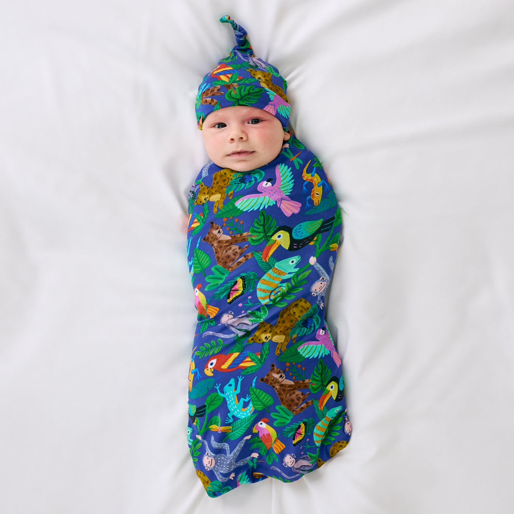 Aerial view of child wearing the Treetop Tails Swaddle & Hat Set