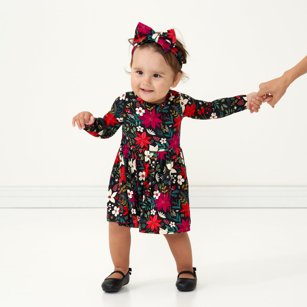 Child wearing a Berry Merry twirl dress with bodysuit paired with a matching Berry Merry luxe bow headband