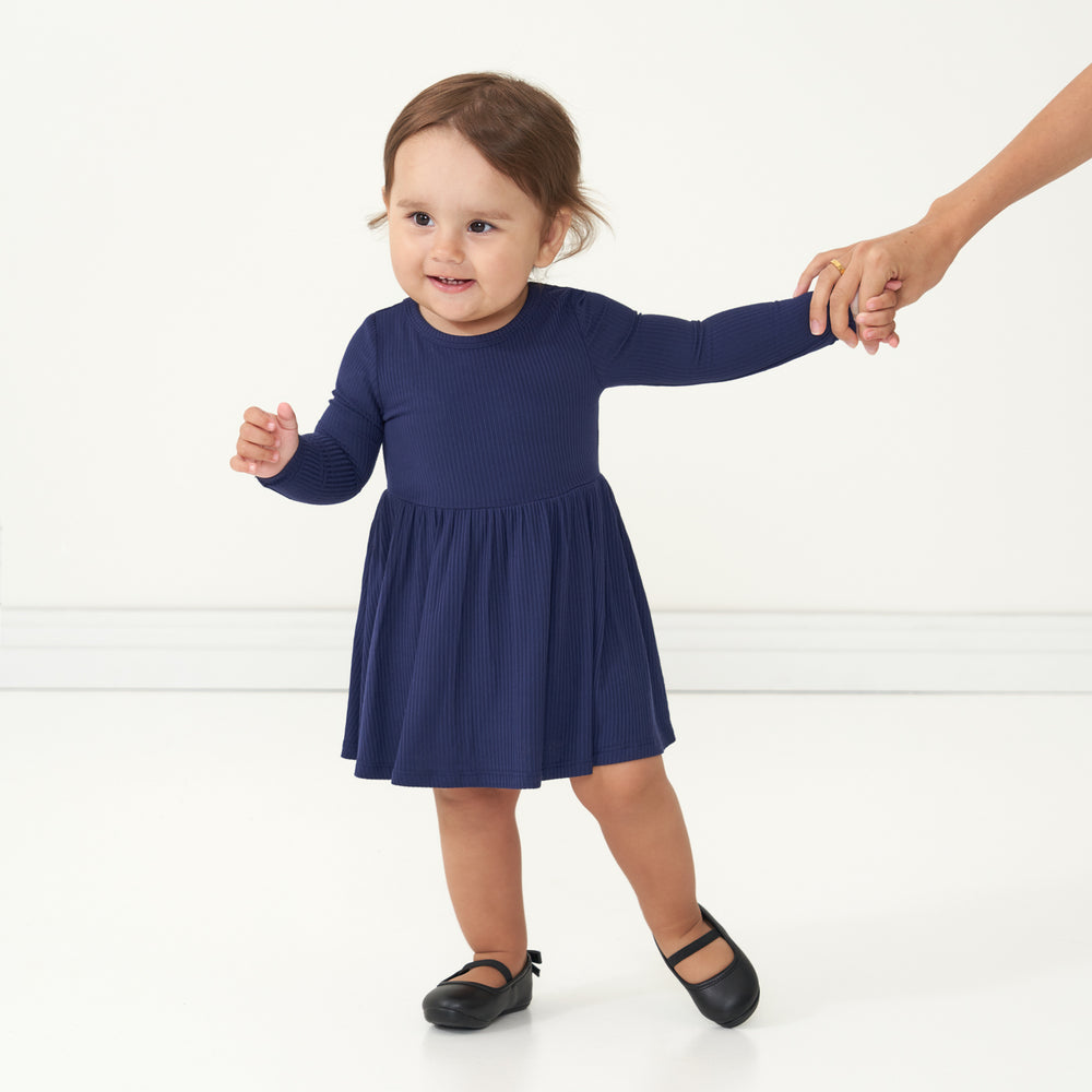 Child holding a parent's hand wearing a Classic Navy ribbed twirl dress with bodysuit