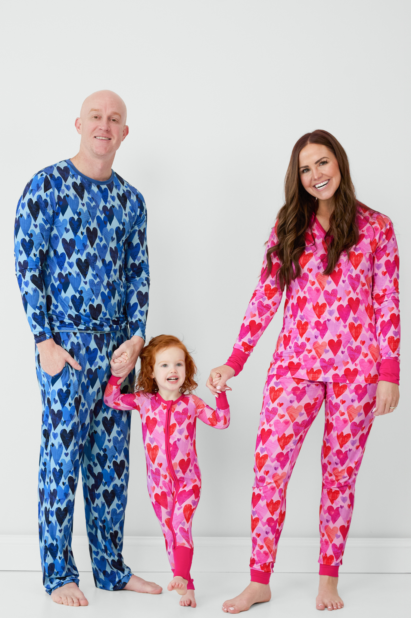 Family of three wearing matching Hearts & Crafts pajamas