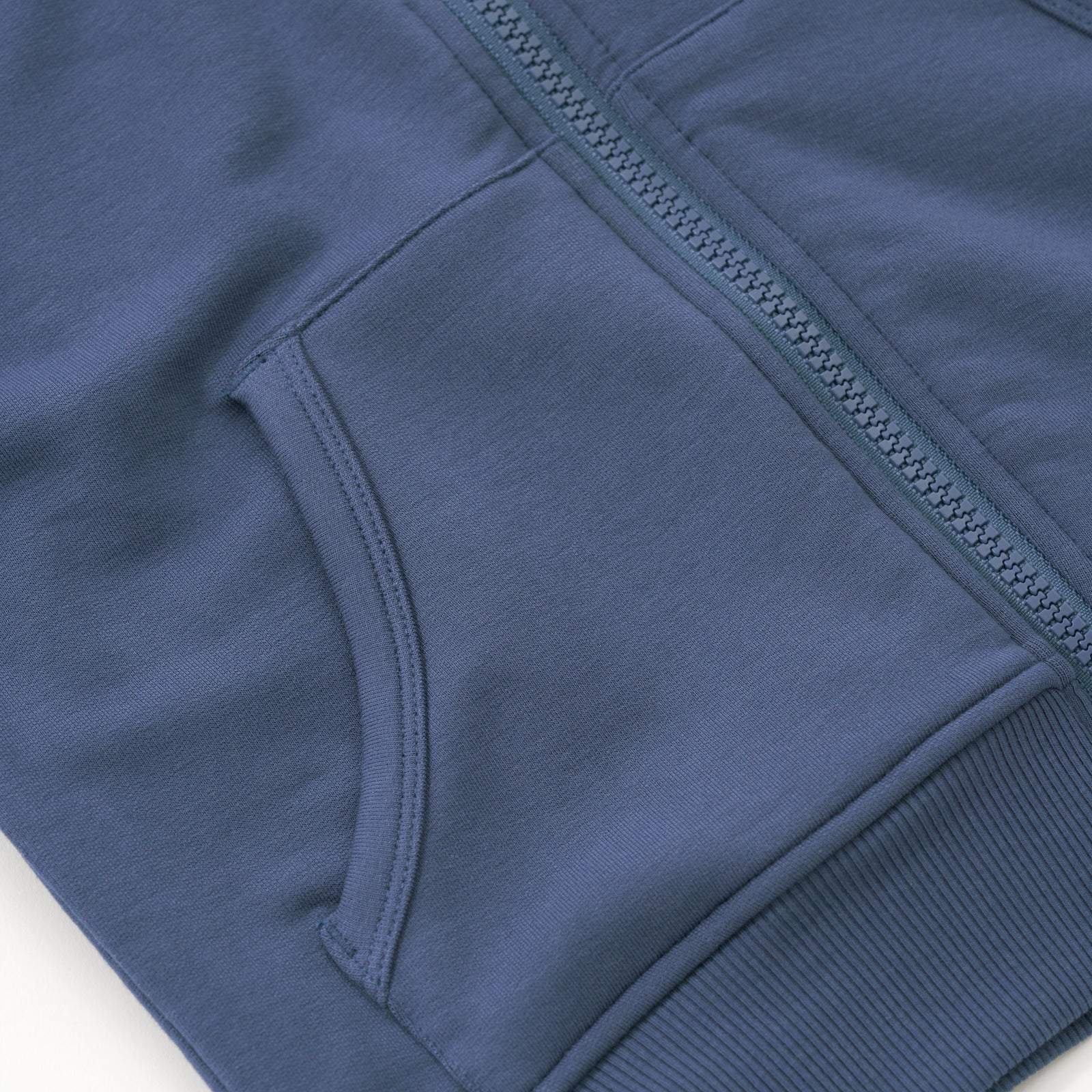 Close up flat lay of the zipper and pocket detail on the Vintage Navy Zip Hoodie