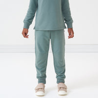 Close up image of a child wearing Vintage Teal joggers