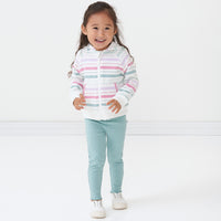 Child wearing Aqua Mist Ribbed cozy lettuce leggings paired with a Winter Stripe zip hoodie