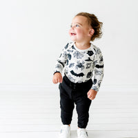 Alternate image of a child wearing a Witches Brew Bodysuit paired with Black joggers
