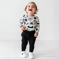 Child wearing a Witches Brew Bodysuit paired with Black joggers