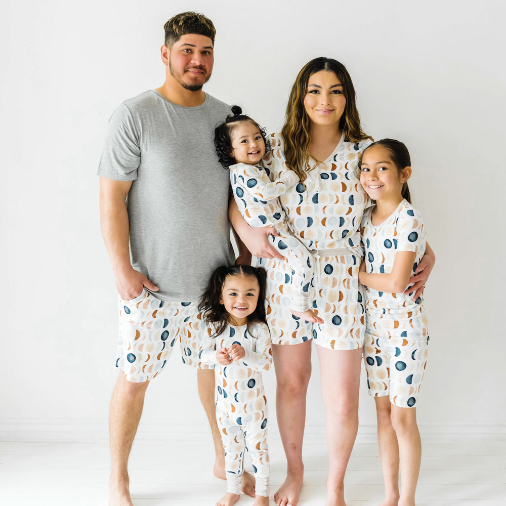 Family of four wearing matching Luna Neutral pjs. Dad is wearing a Heather Gray short sleeve men's pj top paired with mens Luna Neutral  pj shorts. Mom is wearing Luna Neutral women's short sleeve pj top paired with matching women's short sleeve pj shorts. Children are wearing Luna neutral pjs in two piece short sleeve, zippy, and crescent zippy styles