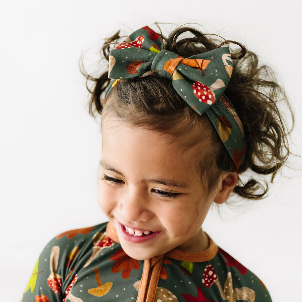 Close up image of a child wearing a Woodland Forest luxe bow headband