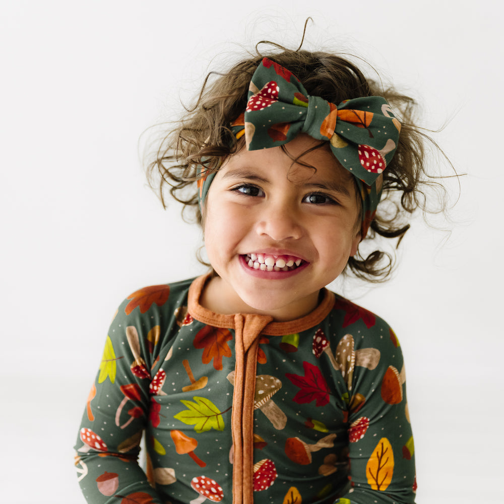 Child wearing a Woodland Forest luxe bow headband and matching zippy