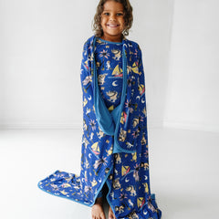 Child wearing Where the Wild Things Are two piece pajama set with a matching cloud blanket wrapped over her shoulders