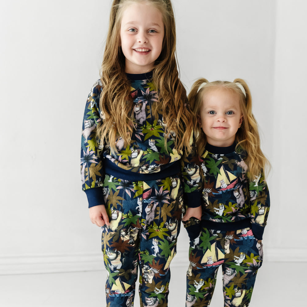image of two children holding hands wearing Where the Wild Things Are crewnecks paired with matching joggers