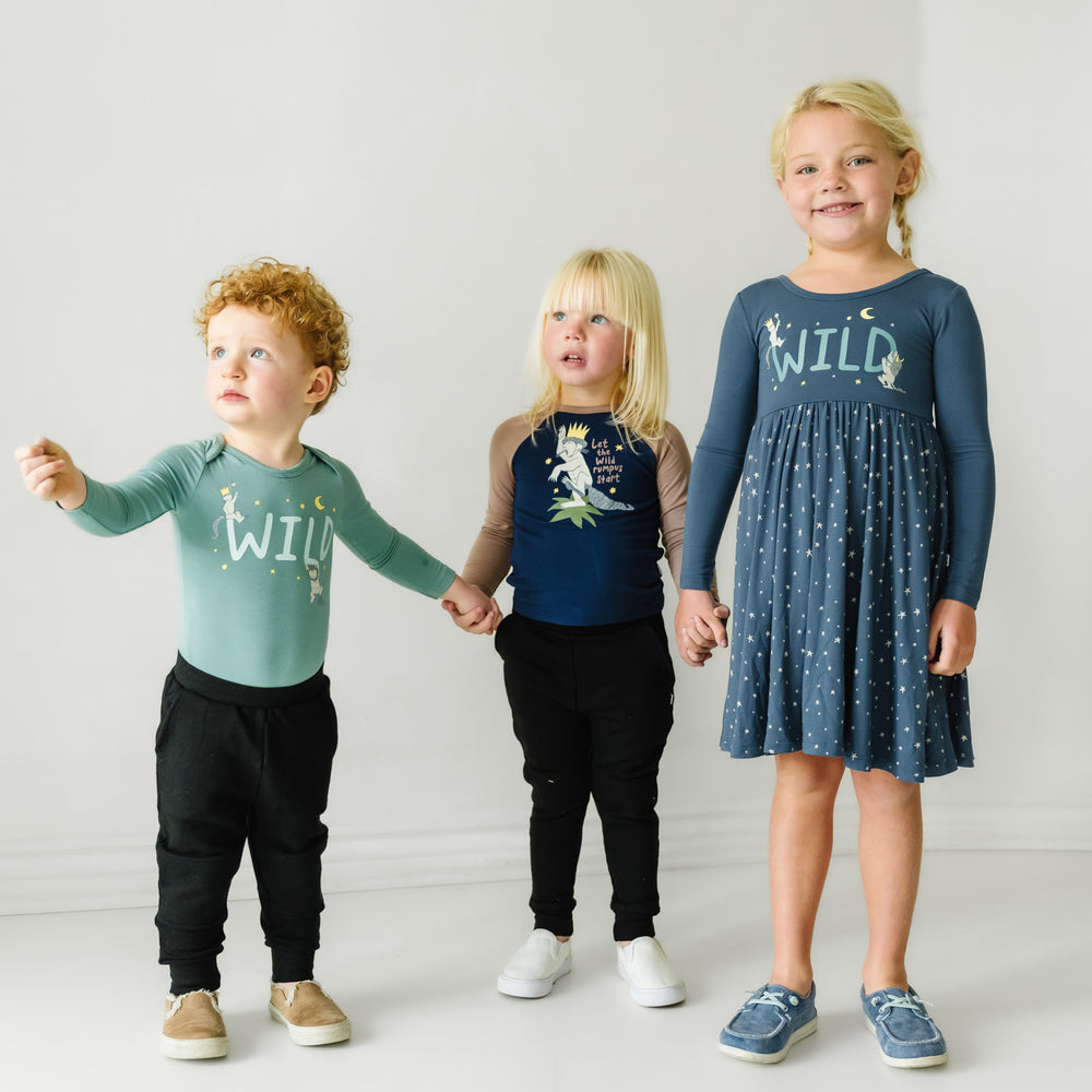 Three children holding hands wearing coordinating Where the Wild Things Are play styles