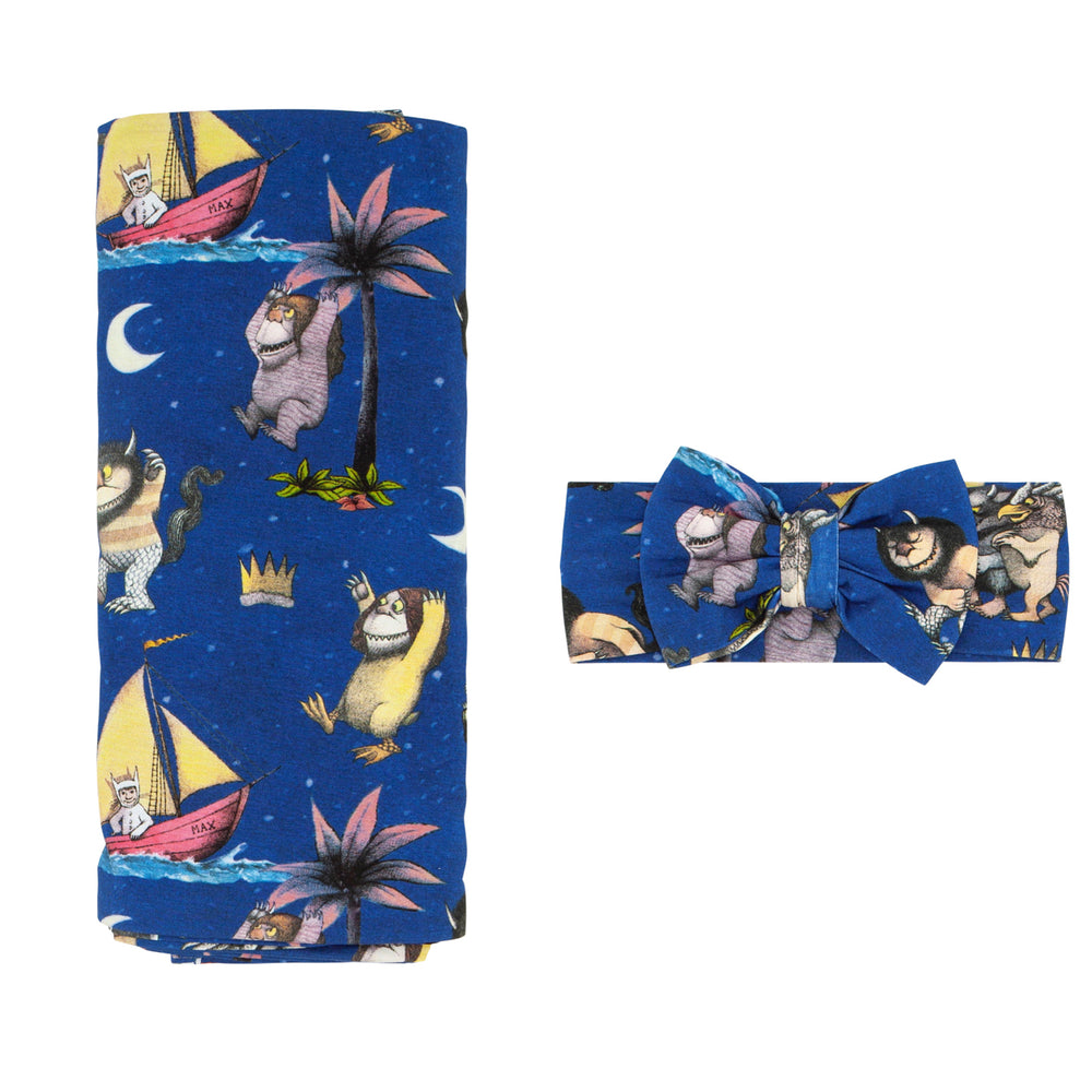 Flat lay image of a Where the Wild Things Are swaddle and luxe bow headband set