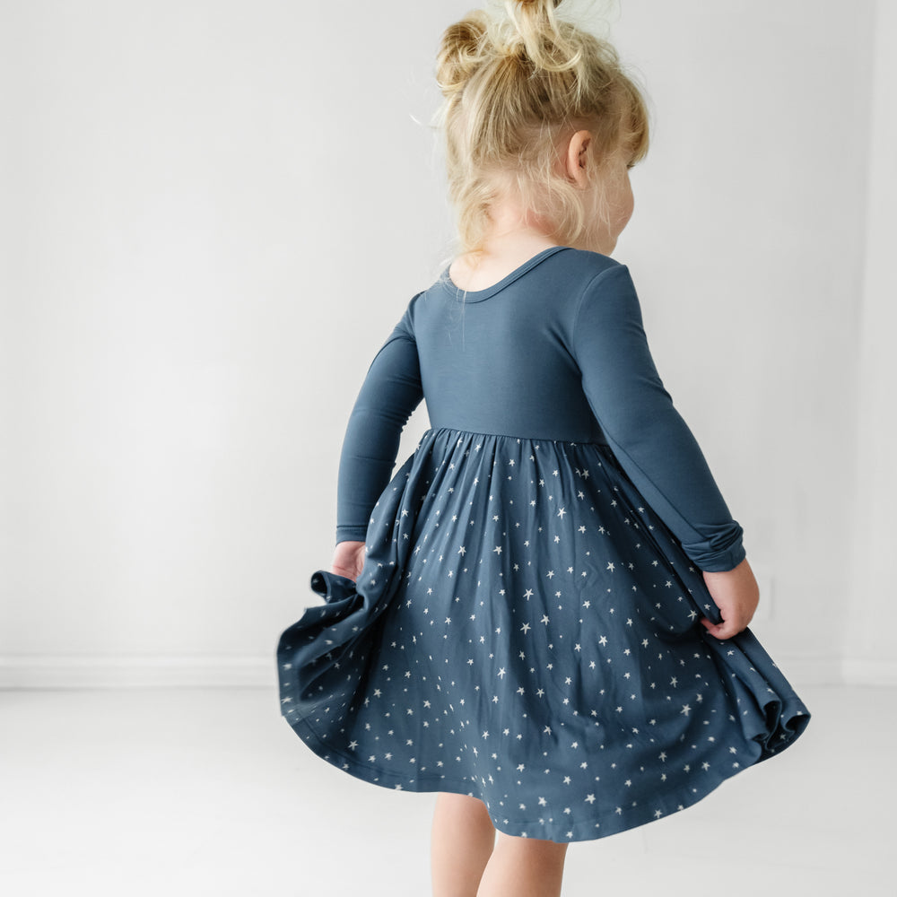 Back of a child twirling wearing a Where the Wild Things Are twirl dress with bodysuit
