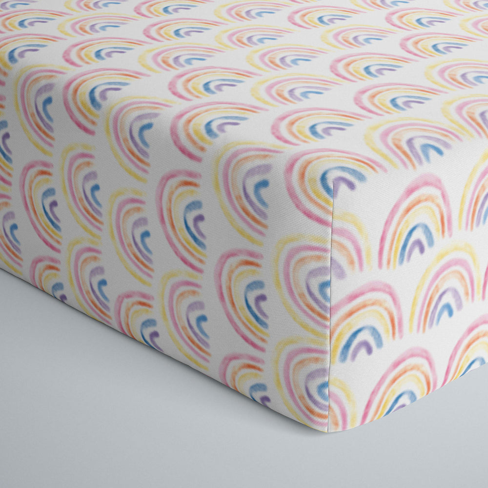 Close up image of infant fitted crib sheet with Pastel Rainbows print