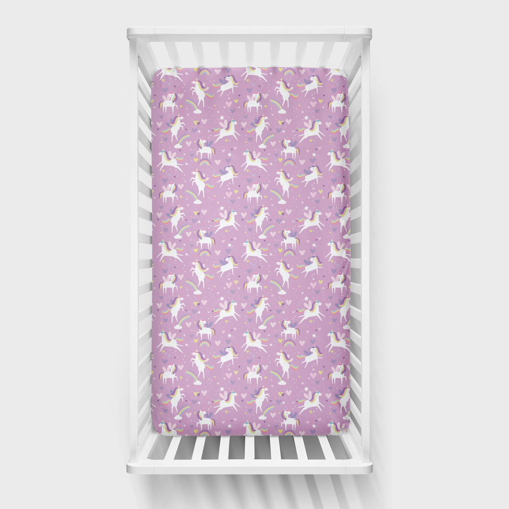 Aerial view of a standard fitted infant crib sheet in Sienna's Unicorns print on a white crib