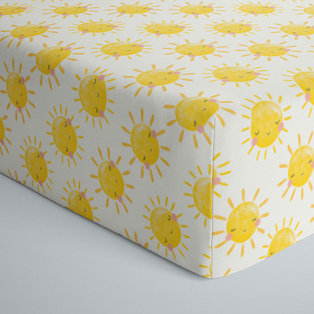 Close up image of infant fitted crib sheet with Yellow smiling sunshines print