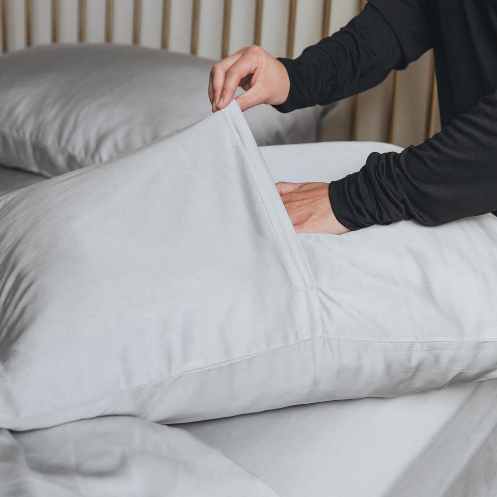 Person demonstrating how to put on the pillow case 