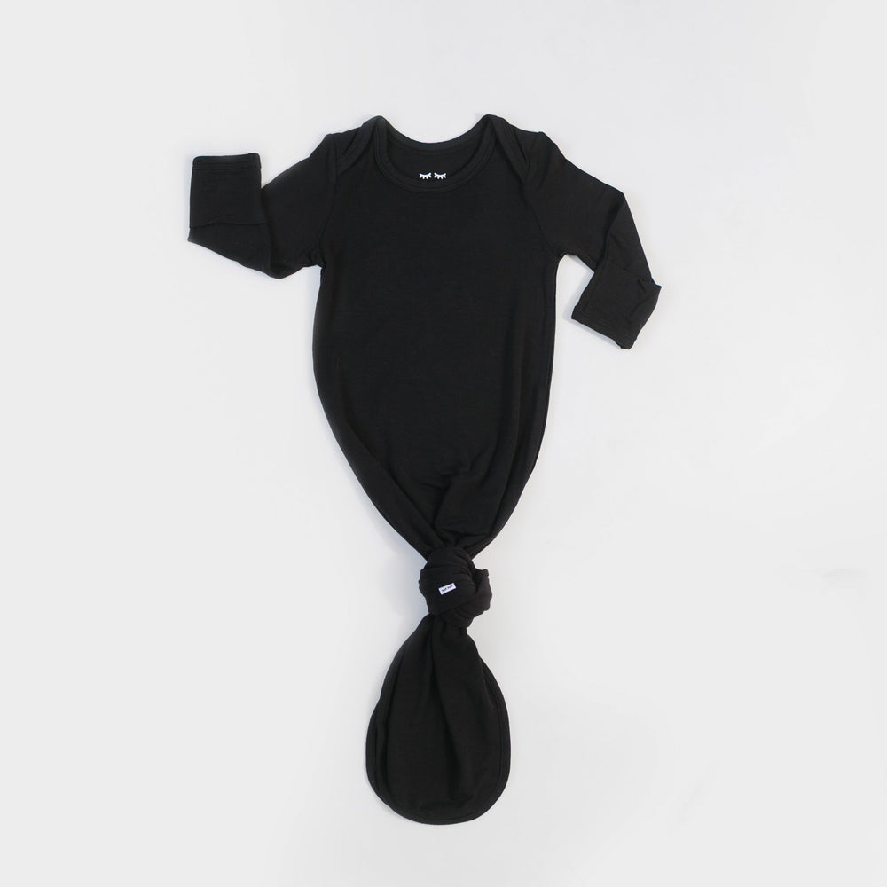 Click to see full screen - Flat lay photo of solid black infant knotted gown 