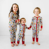 Three children posing together wearing Holiday Treats pajamas in two piece and zippy styles