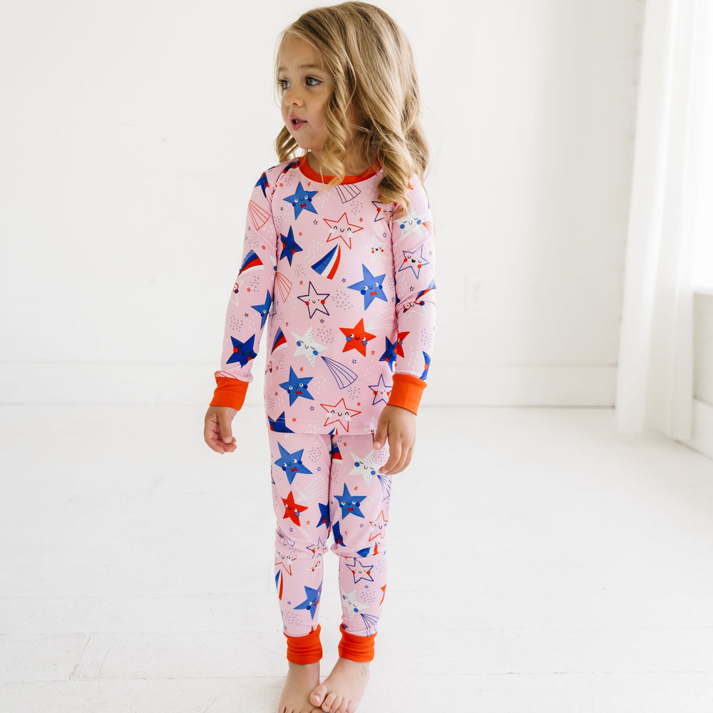 Child wearing a Pink Stars and Stripes printed two piece pajama set