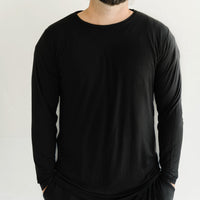 Image of male model wearing a solid black long sleeve pajama top
