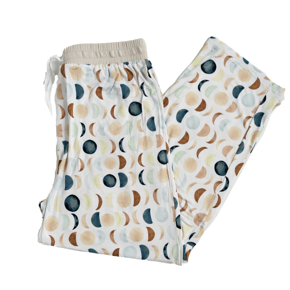 Flat lay image of men's Luna Neutral pajama pants. This print features phases of the moon in the sweetest shades of creams, tans, and navy watercolor in an all over repeat pattern.