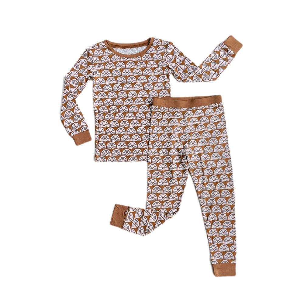 Flat lay image of two-piece pajama set in Rust Rainbows print. This print features white rainbows that sit upon a rust brown background with matching rust brown trim.