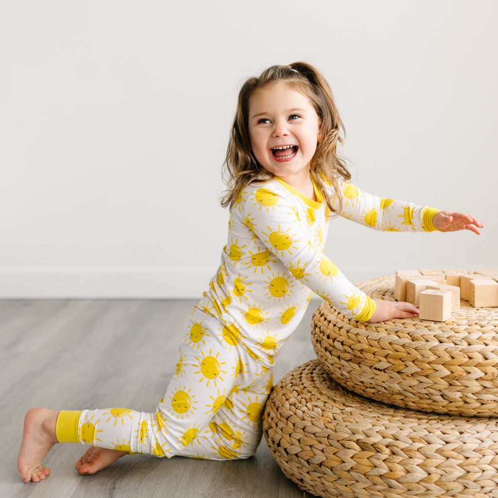 Click to see full screen - Image of child wearing two-piece pajama set with yellow smiling suns