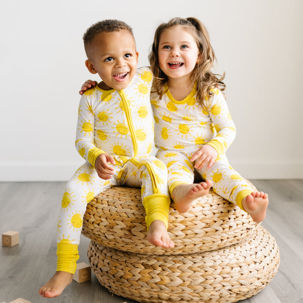 Image of two children wearing matching pajamas with yellow smiling suns